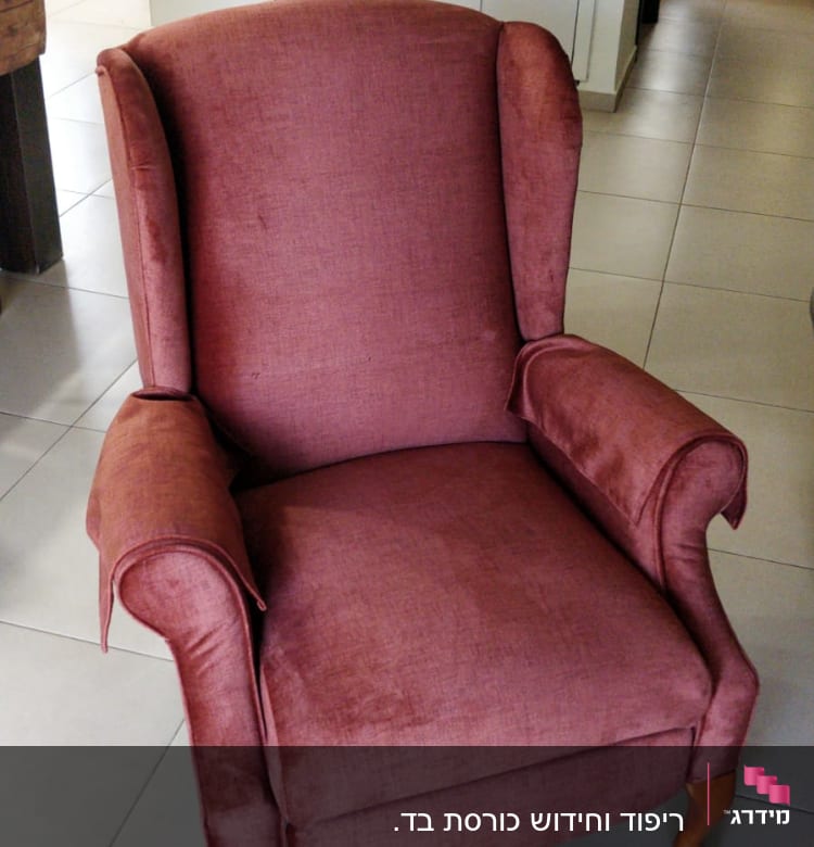 כורסה מרופדת בבד אדום עם רגלי עץ מעוגלות